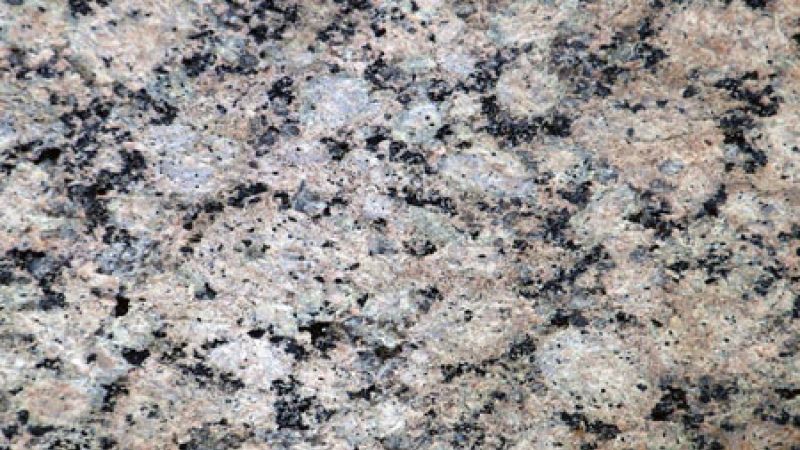 Closeup sample of cut granite stone slab.