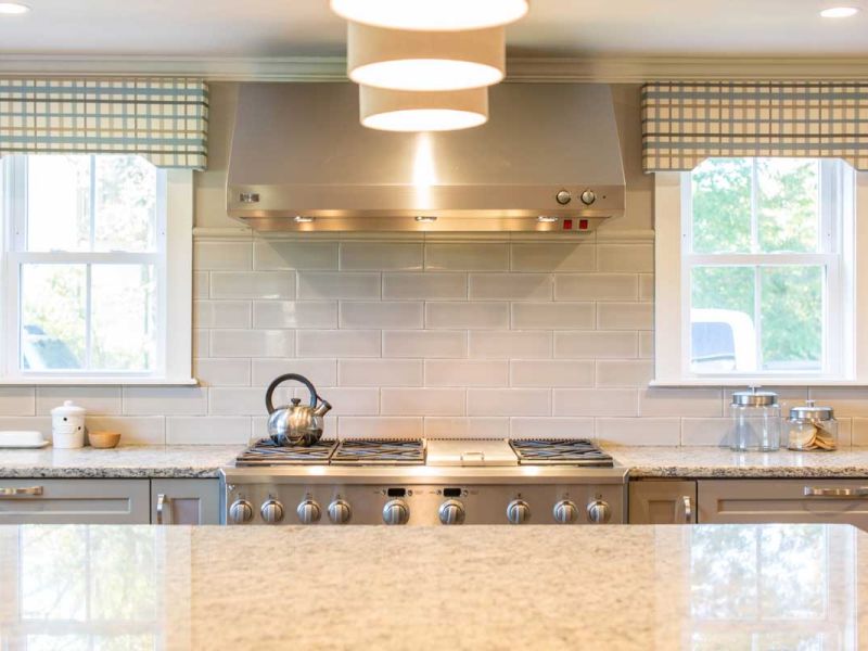 Modern cooktop and island with granite countertops.